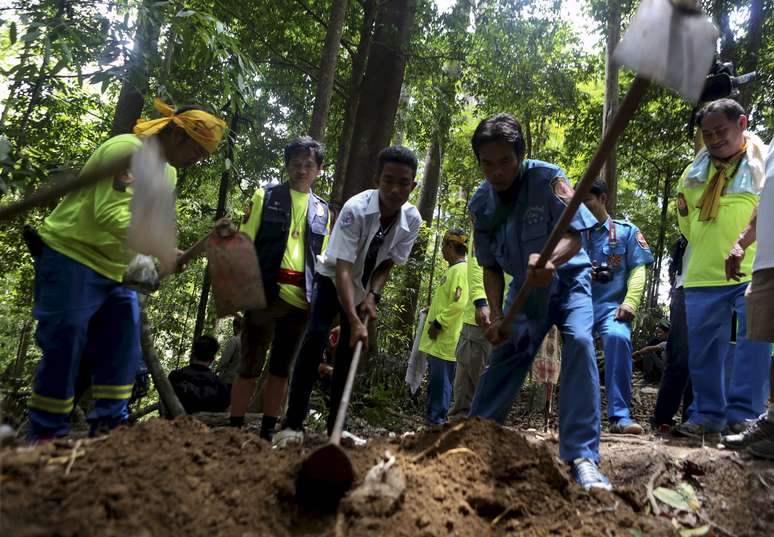 Equipe de resgate inspeciona uma cova em um suposto acampamento de tráfico humano abandonado na Tailândia