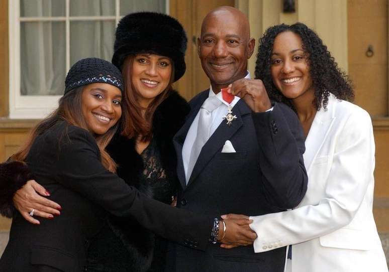 Cantor Errol Brown posa com sua família no Palácio de Buckingham após receber honraria de tornar-se Membro do Império Britânico. 27/11/2003.