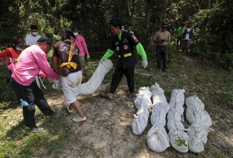 Trabalhadores retirando restos de corpos encontrados na província de Songkhla, no sul da Tailândia.    06/05/2015