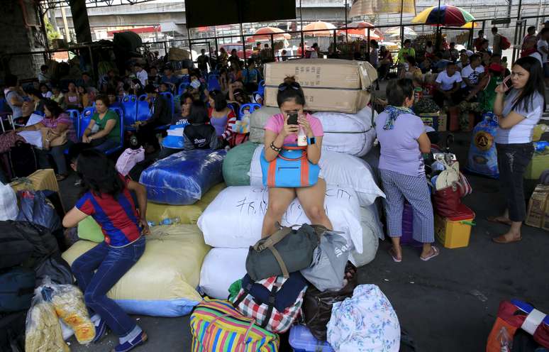 Passageiros aguardam em um terminal de ônibus das Filipinas para deixar áreas de risco antes da chegada do tufão Noul