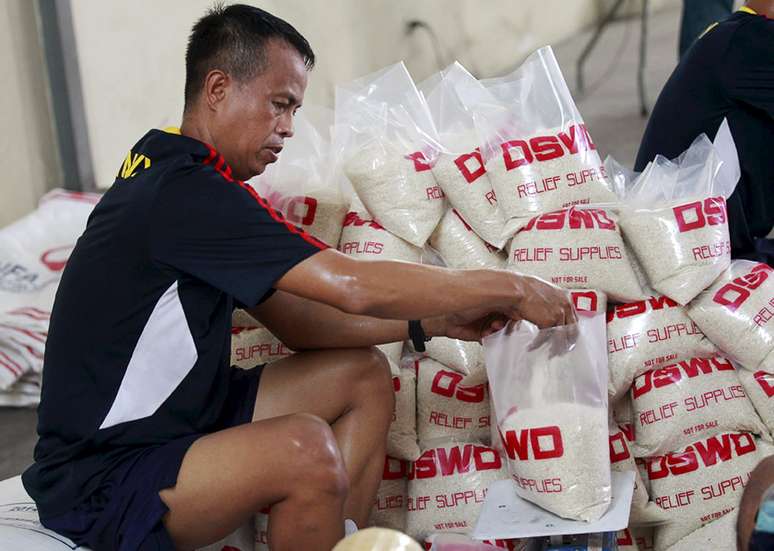 Homem ajuda a organizar suprimentos para desabrigados por tufão