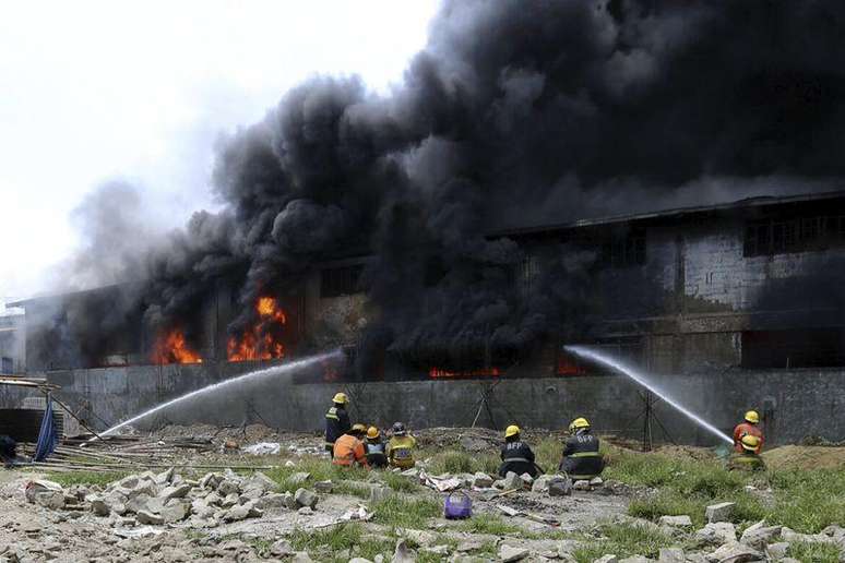 Bombeiros combatem as chamas em incêndio em fábrica perto de Manila. 13/05/2015