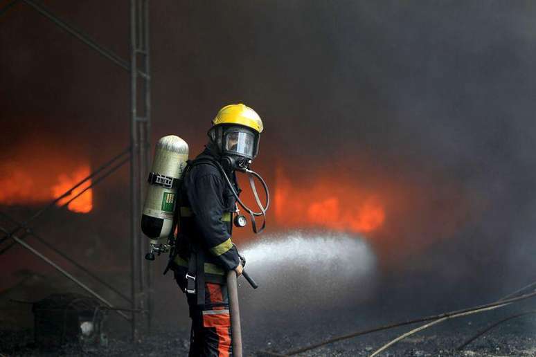 Bombeiro combate as chamas em fábrica de Manila, nas Filipinas. 13/05/2015