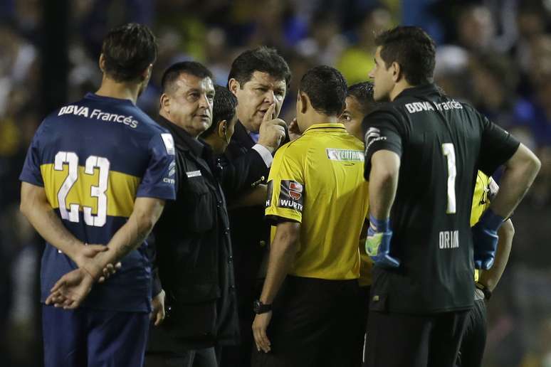 Delegado da Conmebol, Roger Bello (centro) conversa com o árbitro do duelo, Dario Herrera