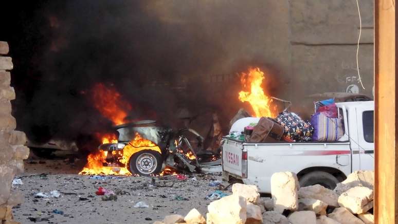 Carros em chamas durante combate na cidade iraquiana de Ramadi