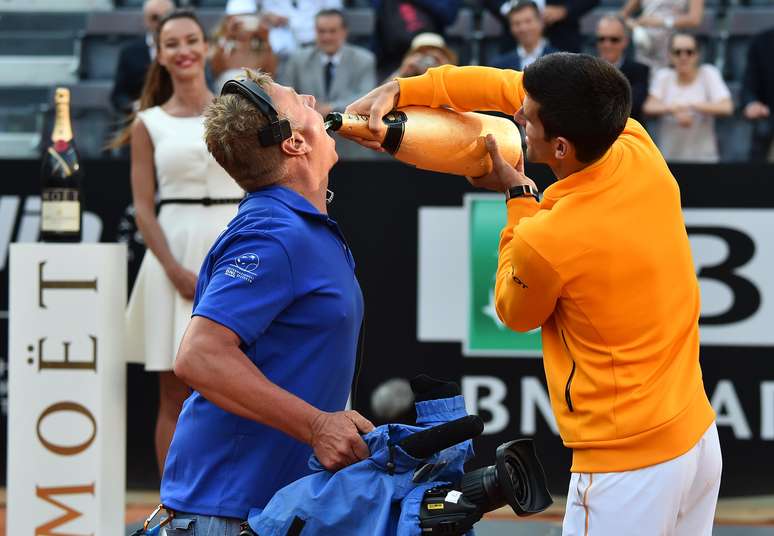 Djokovic d&aacute; at&eacute; champagne para um c&acirc;mera