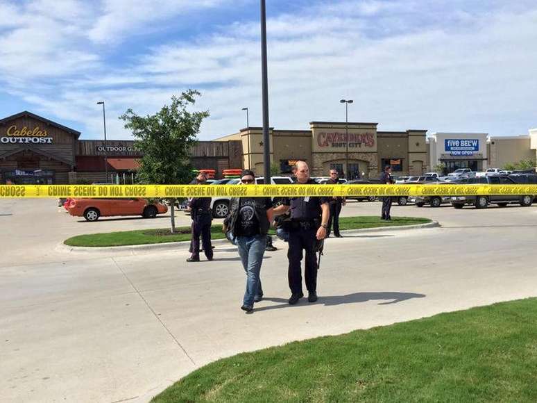 Policial escoltando um homem na cena do tiroteio em Waco, no Texas. 18/05/2015