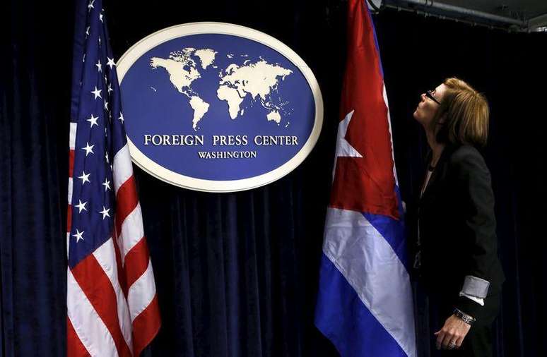 Funcionária coloca bandeiras de Estados Unidos e Cuba em sala de imprensa antes de entrevista coletiva em Washington. 22/05/2015