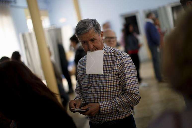 Homem segurando cédula com a boca antes de votar, na Espanha. 24/05/2015