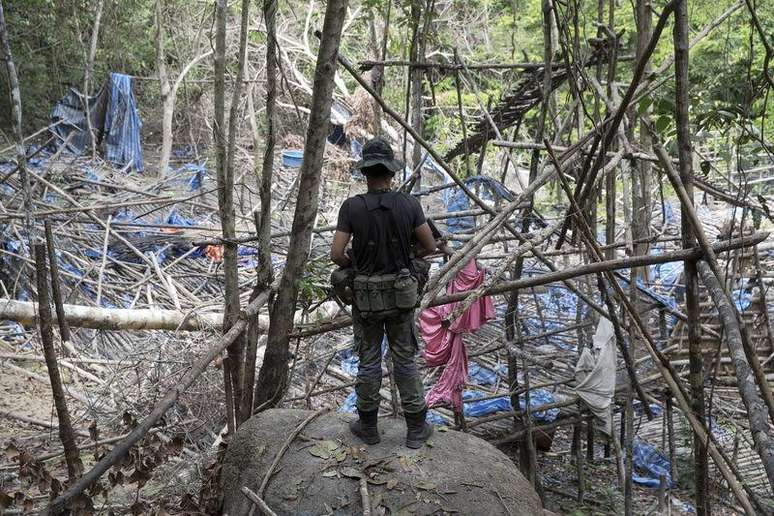 Policial observa acampamento abandonado por supostos traficantes de pessoas numa floresta da Malásia. 26/05/2015