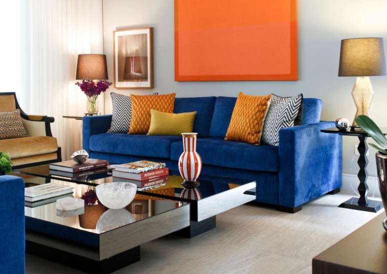 Montada com combinação de azul e cores quentes, esta sala inclui detalhes naturais e objetos decorativos modernos