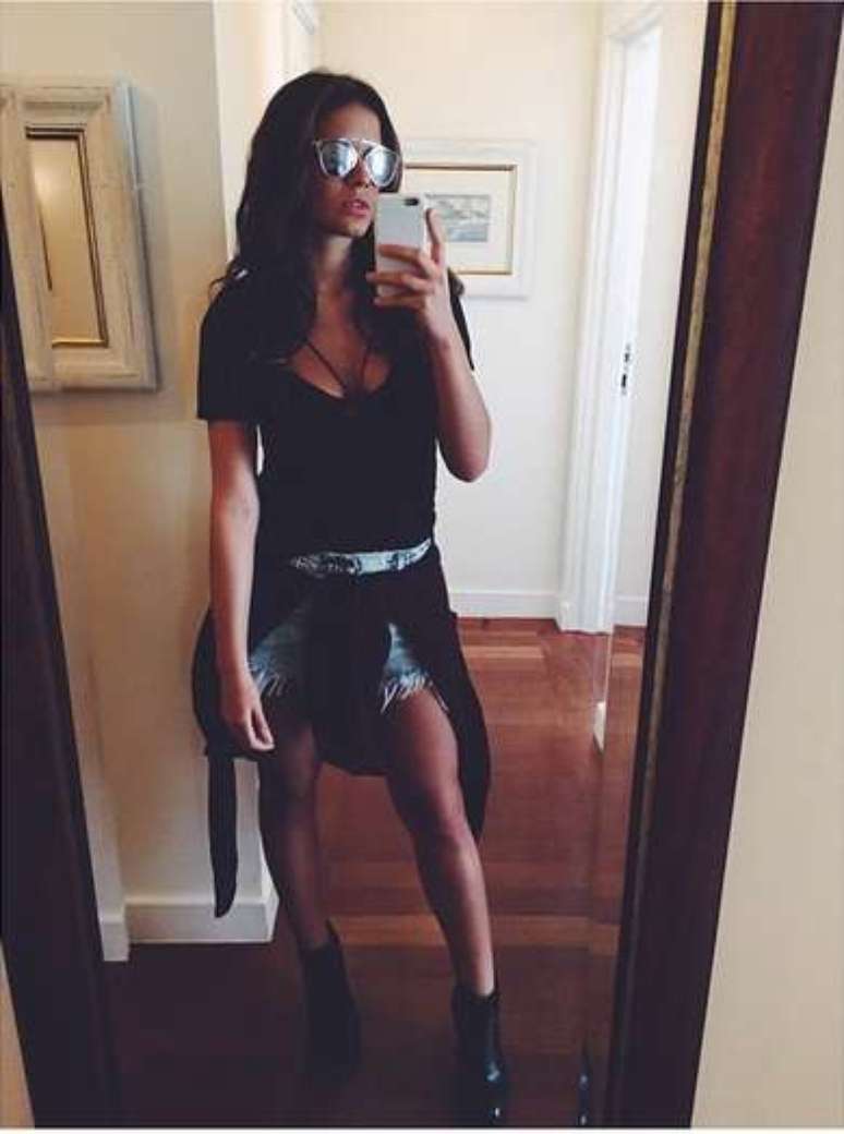 Shorts jeans, camiseta, botinha e blusa amarrada na cintura e os óculos compõem o look de Bruna que ela fez questão de postar no Instagram