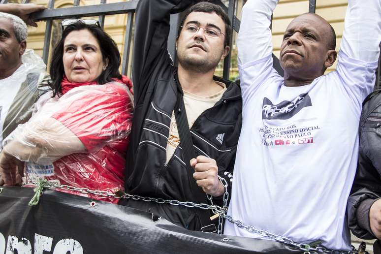 Professores da rede estadual ensino de São Paulo em greve se acorrentam protestando em frente à secretaria