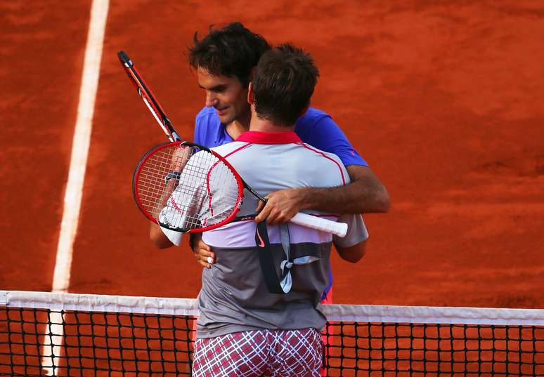 Amigos fora de quadra, Federer e Wawrinka se abraçam após partida