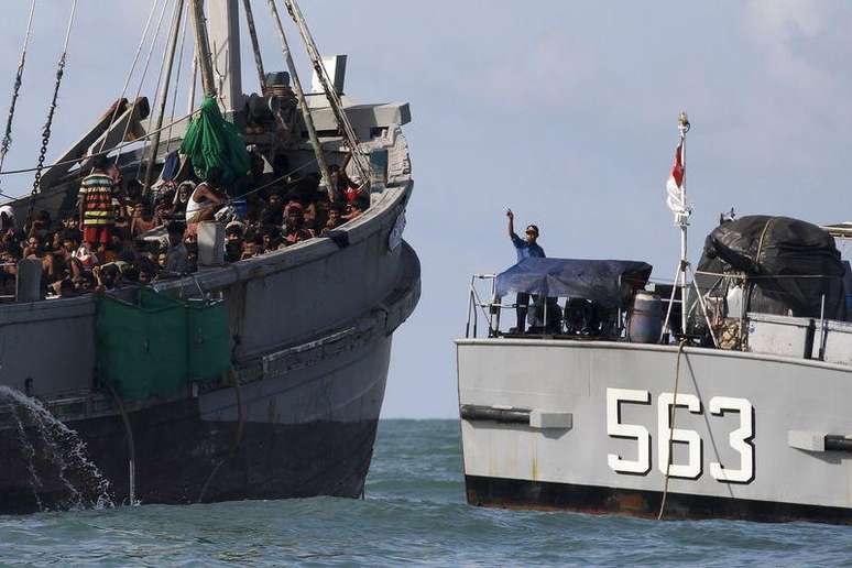 Oficial de barco militar de Mianmar fala com imigrantes em barco no mar de Andaman. 31/05/2015