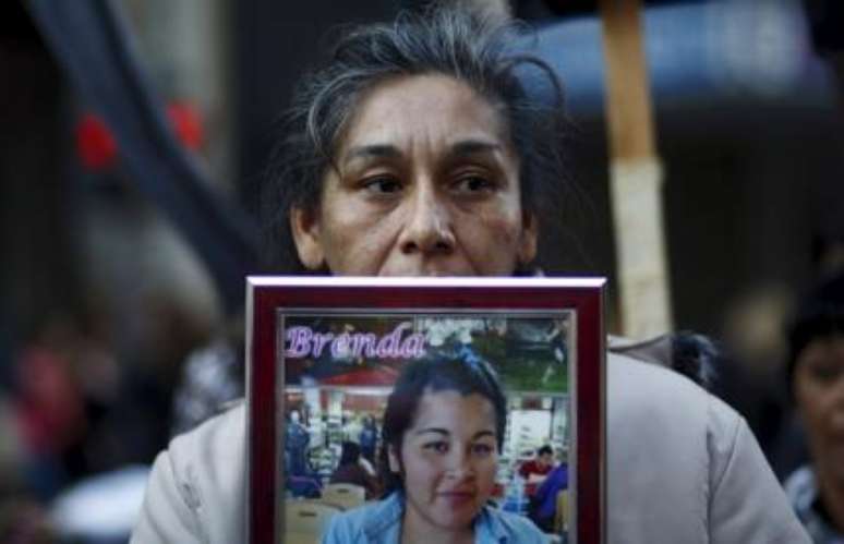 A argentina Teresa Ponce carrega foto da filha Brenda, que foi queimada pelo marido, em marcha contra o feminicídio em Buenos Aires