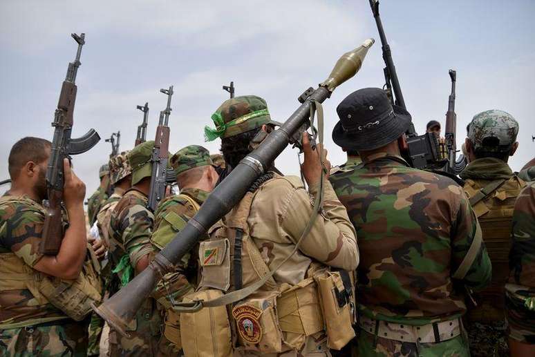 Iraquianos carregam armas ao se aproximarem de Baiji.  3/6/2015.