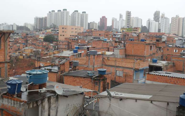 Imagem do alto da comunidade; ao fundo, prédios do Morumbi