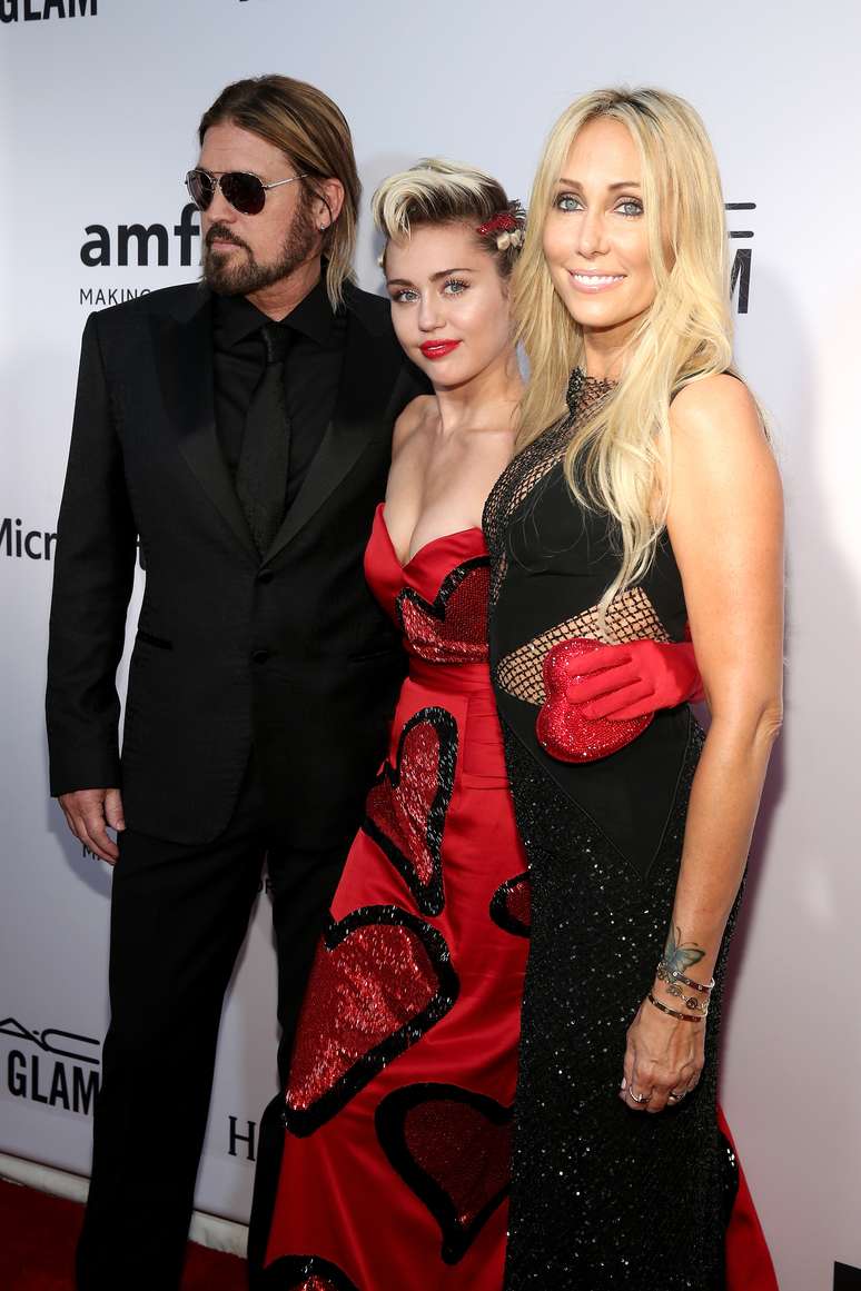 Miley Cyrus posa entre o pai, Billy Ray Cyrus, e a mãe, Tish Cyrus