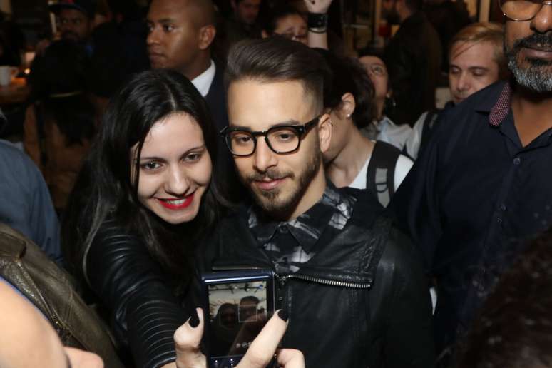 O cantor J&uacute;nior Lima atende f&atilde;s durante o lan&ccedil;amento de sua primeira exposi&ccedil;&atilde;o, "Faces", na galeria Matilha Cultural, na regi&atilde;o central de S&atilde;o Paulo, nesta ter&ccedil;a-feira (16)