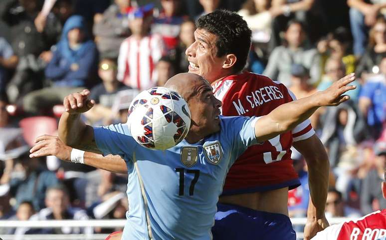 Marcos Cáceres disputa lance contra Arévalo Ríos no jogo entre Paraguai e Uruguai na primeira fase