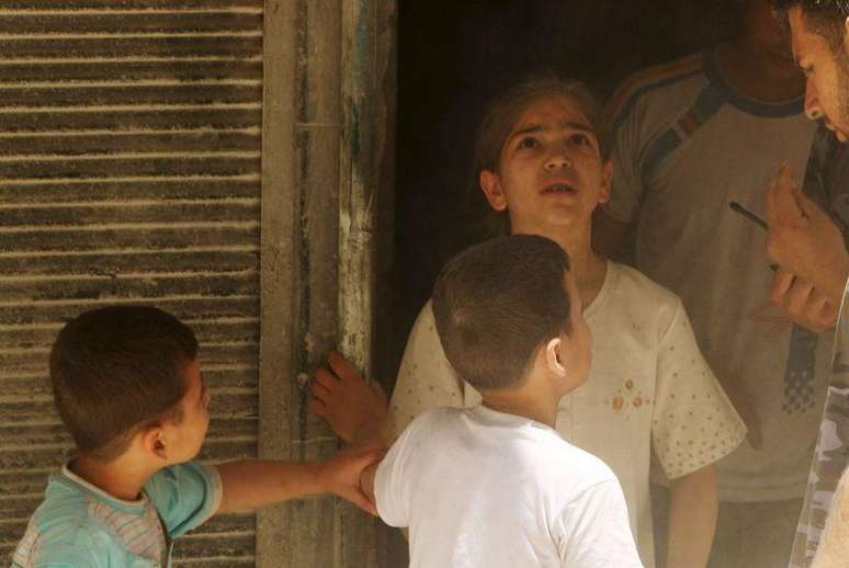 Crianças em local atingido por bombas lançadas por forças leais ao presidente sírio Bashar al-Assad, em Aleppo. 21/06/2015