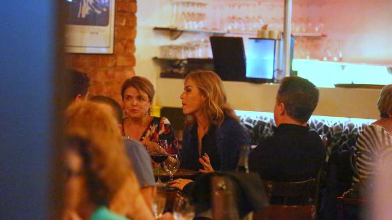 Angélica com o marido, Luciano Huck (de costas), e a irmã Márcia Marba em restaurante na Barra da Tijuca, na noite desta terça-feira (23)