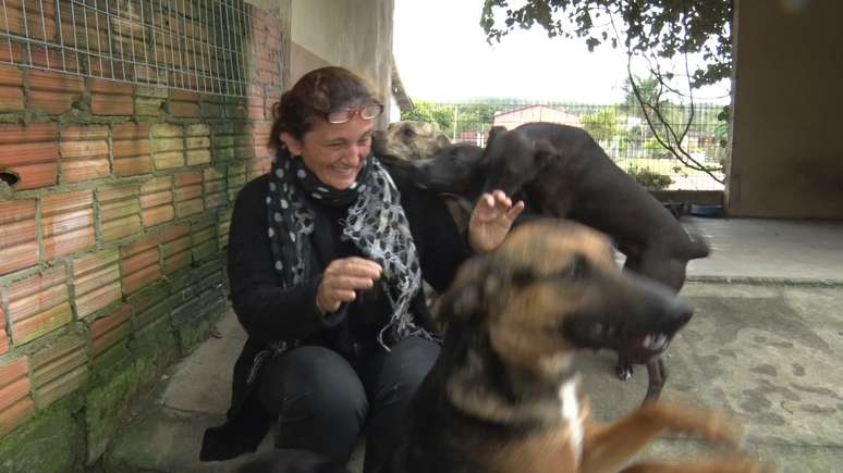 Raquel, administradora do local, brinca com os cães