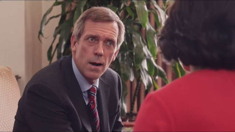 Hugh Laurie interpretando o bem humorado político Tom James