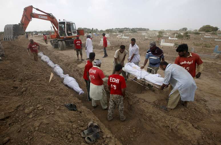 Voluntários enterram em um cemitério em Karachi os corpos de pessoas que morreram devido a onda de calor intenso no Paquistão
