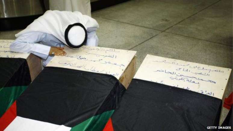 Um kuwaitiano se inclina sobre o caixão de um familiar morto durante o ataque contra uma mesquita na última sexta-feira