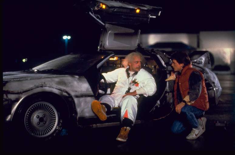 Dr. Emmett Brown (à esq.) e Marty McFly discutem no Delorean, a máquina do tempo