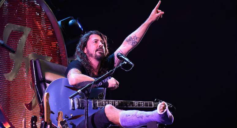 Dave Grohl se apresenta em "trono" com a perna engessada