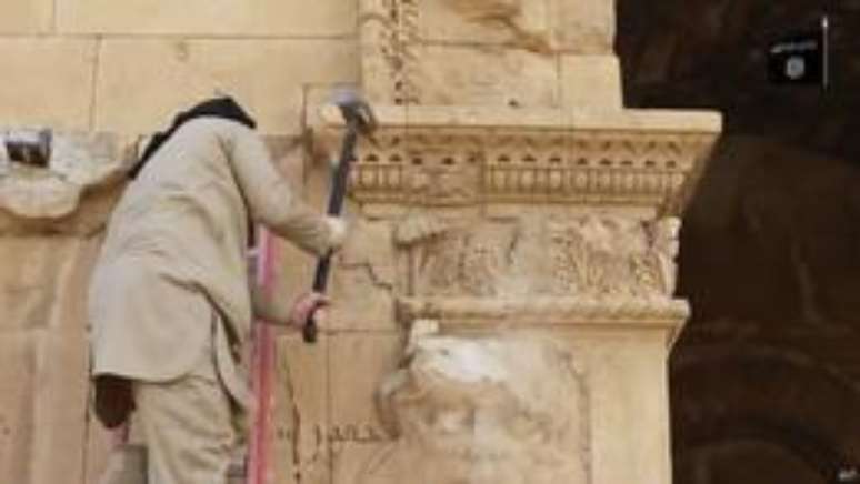 Militante do EI destr&oacute;i parte de muro de Hatra, patrim&ocirc;nio hist&oacute;rico da Unesco, perto de Mosul, no Iraque, em v&iacute;deo militante postado no YouTube: especialistas temem que tesouros arqueol&oacute;gicos estejam sob risco em &aacute;reas controladas pelo grupo