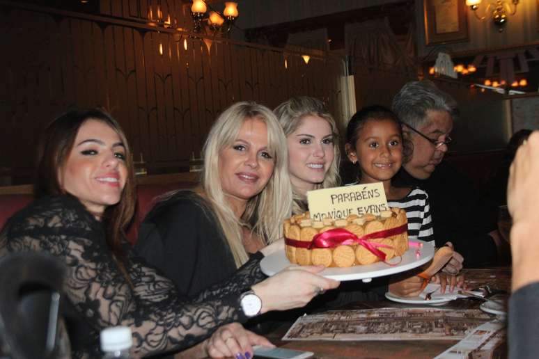 Monique Evans segura bolo ao da namorada, Cacá Werneck (à esq.), da filha, Bárbara, e da neta, Valentina,na noite deste domingo (5)