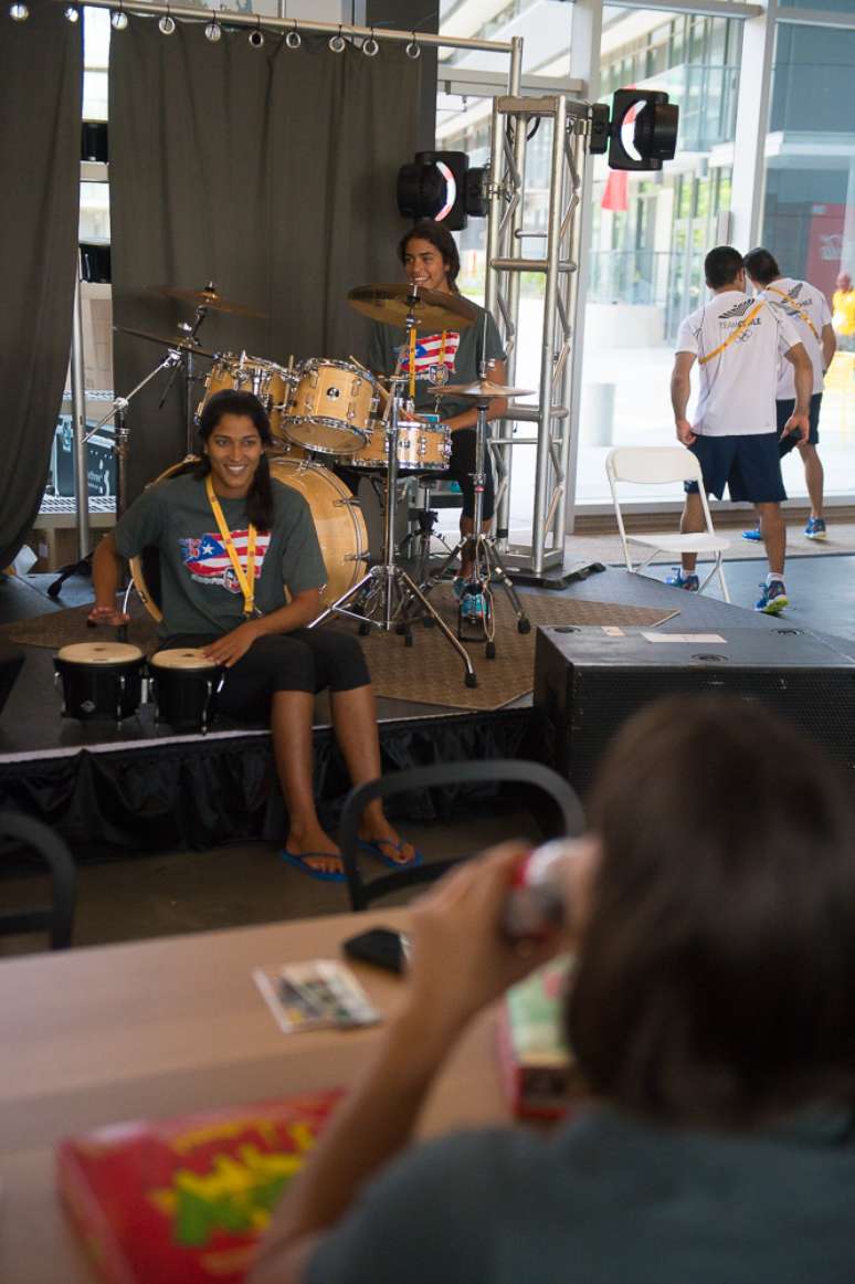 Atletas tocam instrumentos musicais em lounge dentro da Vila