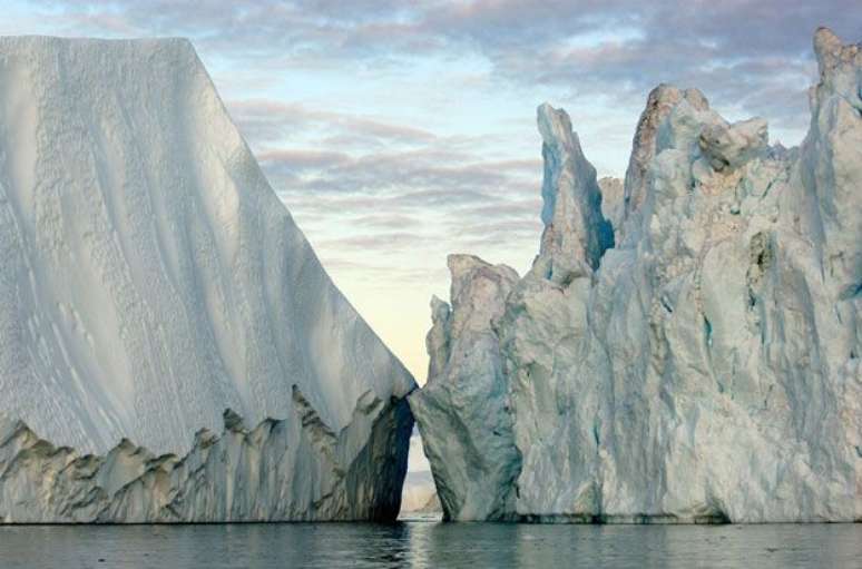 Esta foto registra os blocos de gelo que se elevam a 60 metros da superfície da água, flutuando no Atlântico Norte. A foto foi feita na Groenlândia, em 2007, por James Balog.