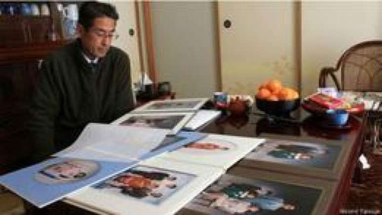 Takamatsu observa álbuns da família: ele diz que seguirá com as buscas enquanto puder