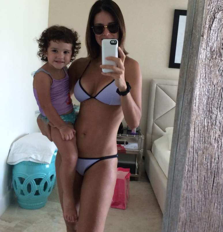 Apresentadora de 39 anos postou selfie de biquíni com a filha caçula no colo