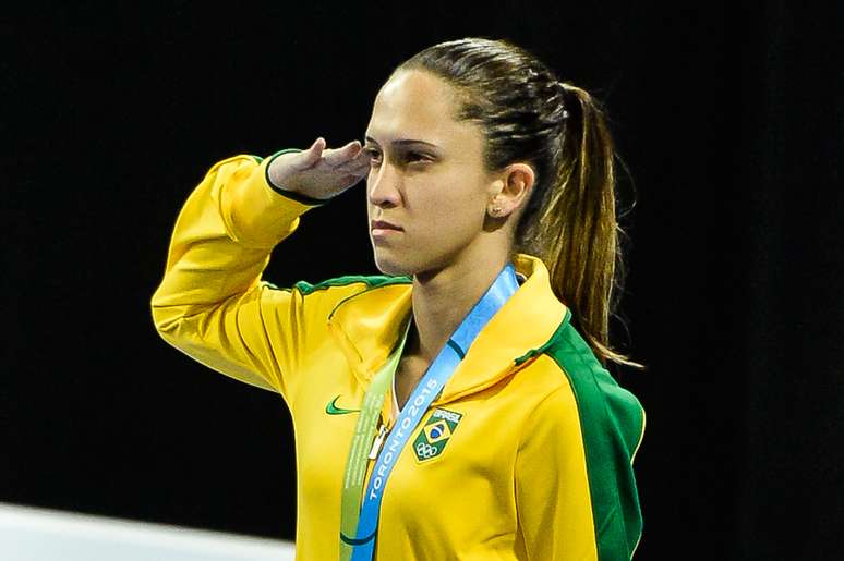 Iris Sing presta continência com medalha de bronze no pódio