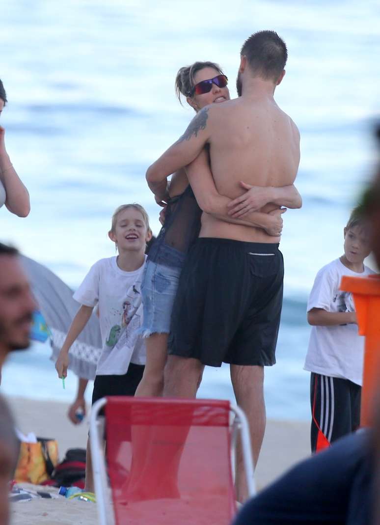 Rodrigo Hilbert abraça Fernanda Lima na praia do Leblon, no Rio de Janeiro, neste domingo (19)