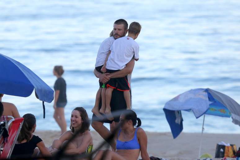 Rodrigo Hilbert carrega os filhos na praia do Leblon, no Rio de Janeiro, neste domingo (19)