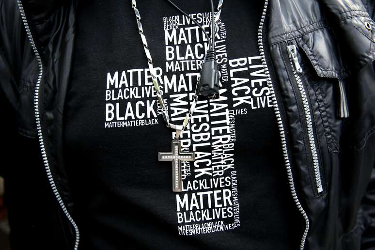Manifestante exibe camiseta com nome do movimento "Black Lives Matter" em formato de crucifixo