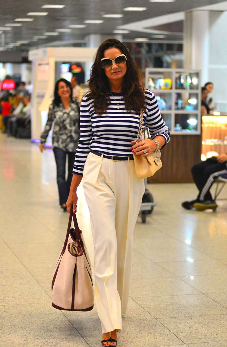 Quer acertar mesmo no estilo navy? Então é só copiar o look de Luiza Brunet. A camiseta listrada com a calça off-white em corte de alfaiataria fica um conjunto casual e elegante. Ela ainda leva bolsa de mão e o modelo Chanel bege. Aliás, foi a estilista francesa que imortalizou o look nos anos 20 e 30 para suas viagens ao balneário de Deauville, na França. Eterno