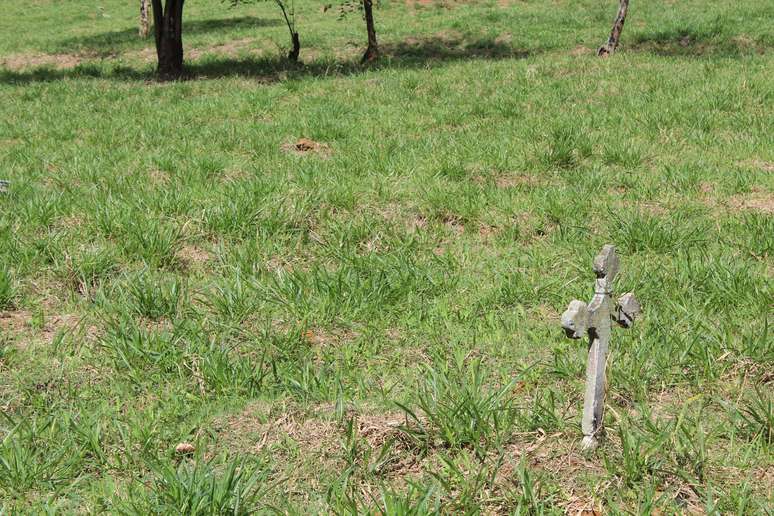 Quadra abandonada com uma cruz solitária, quase sem identificação