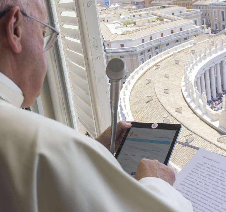 Da janela do Vaticano, Papa Francisco usa um tablet, durante a oração do Angelus