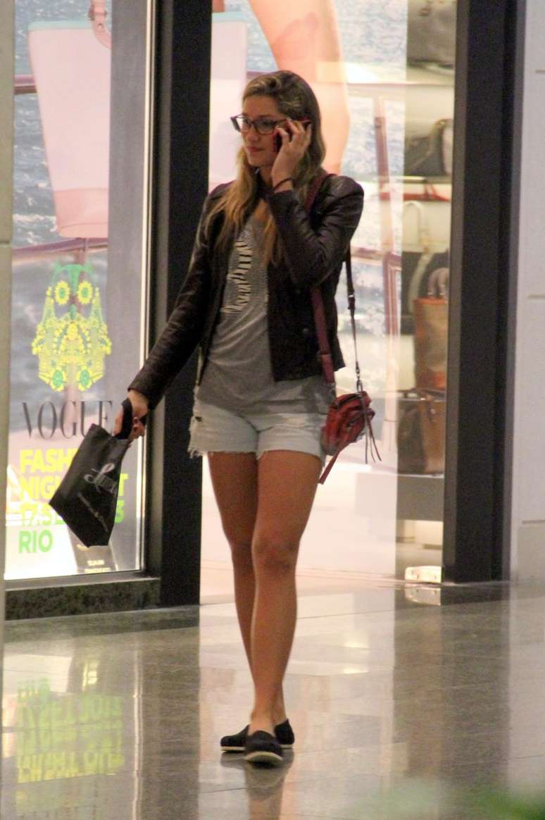 Como é alta, Sasha usa muitos calçados baixos, como essas alpargatas combinadas com shorts jeans, camiseta e jaqueta de couro. Os óculos são grandes e modernos