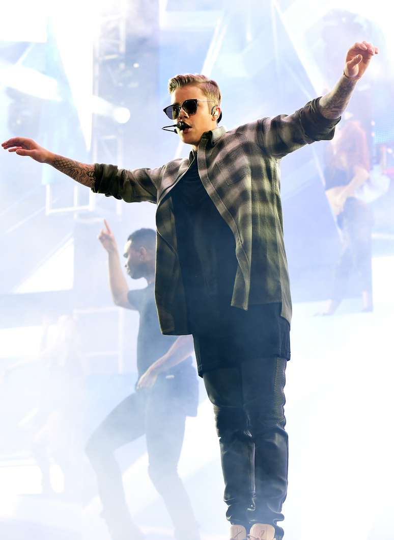 Em outra parte do show, Justin Bieber acrescenta camisa xadrez à sobreposição das camisetas