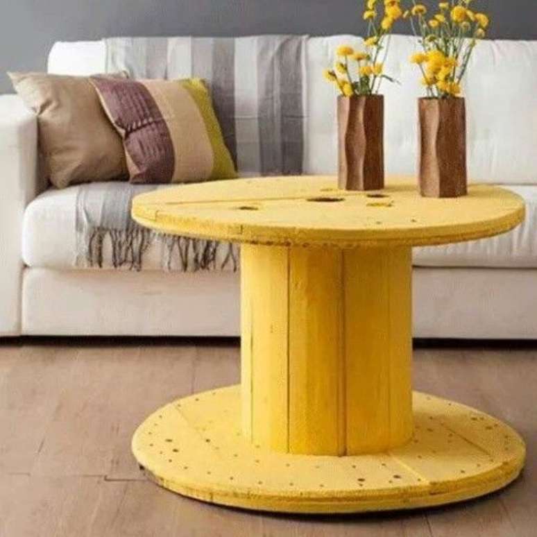 O carretel pintado de amarelo se transformou em uma mesa de centro