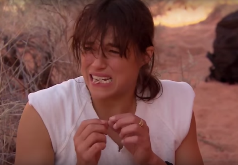 Michelle Rodriguez faz cara de nojo ao comer o rato, que está entre seus dentes, durante programa da TV britânica